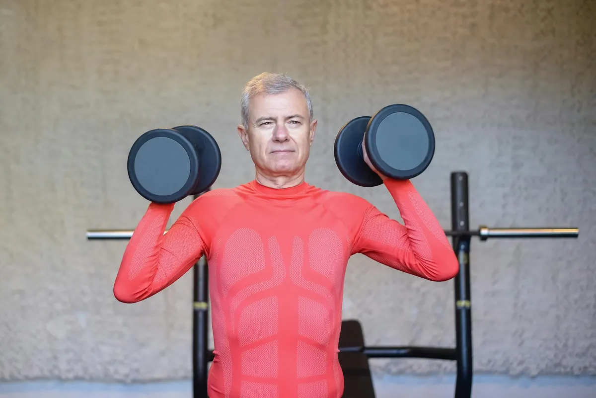 An older adult smiling while performing a bodyweight squat, demonstrating strength and independence.