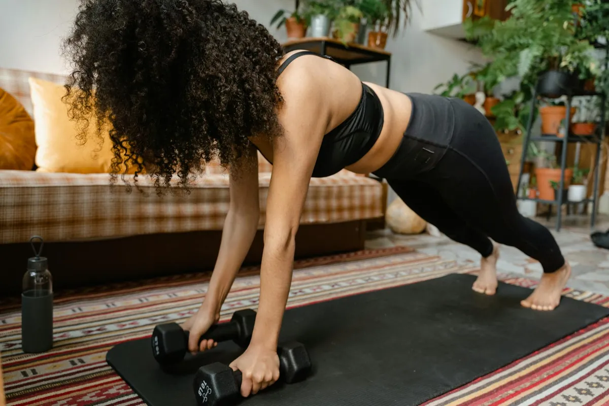 A woman performing bodyweight squats in a compact living room, demonstrating a home strength workout without equipment.