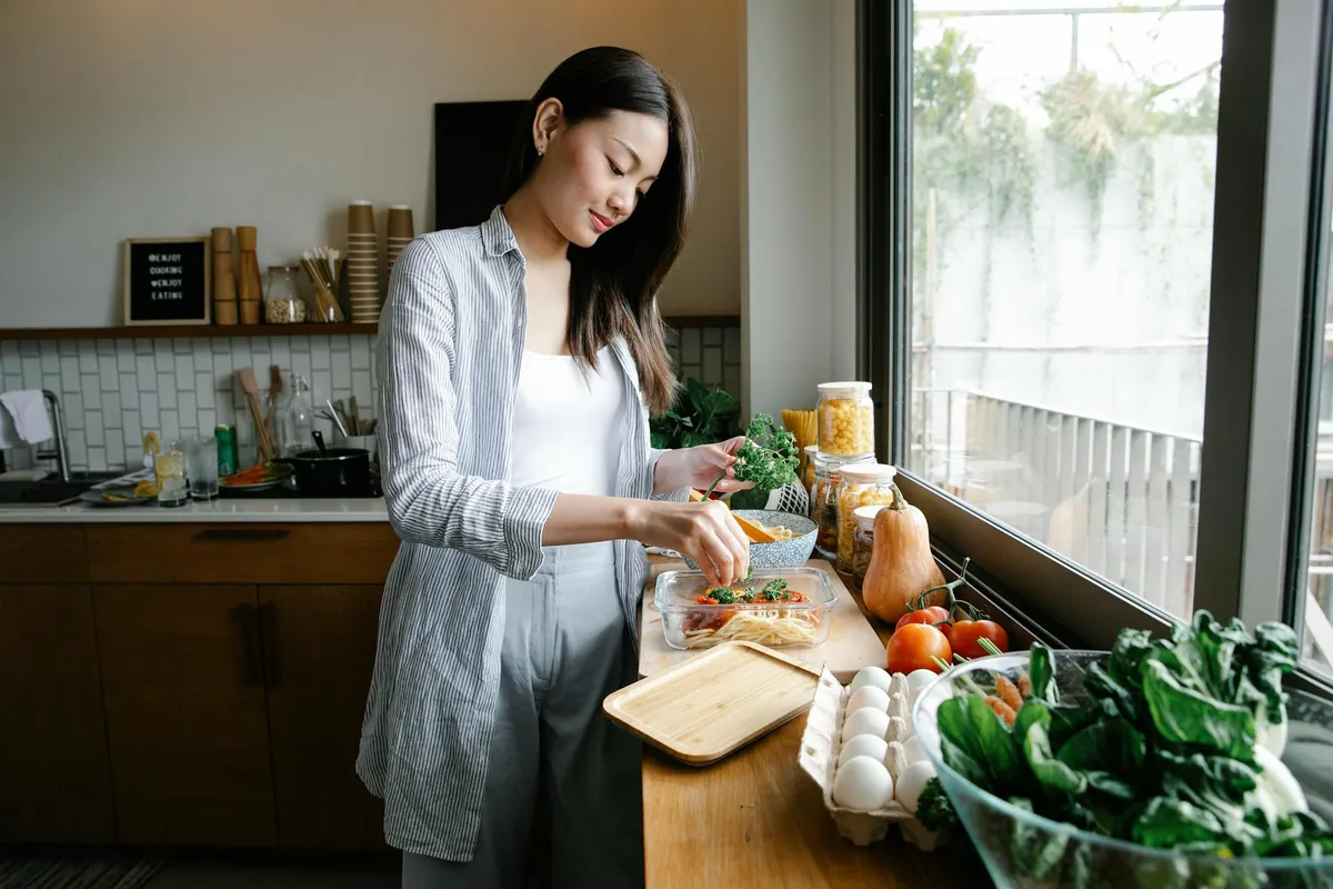 A woman looking thoughtfully at a healthy meal, symbolizing the start of her intermittent fasting journey for weight loss.