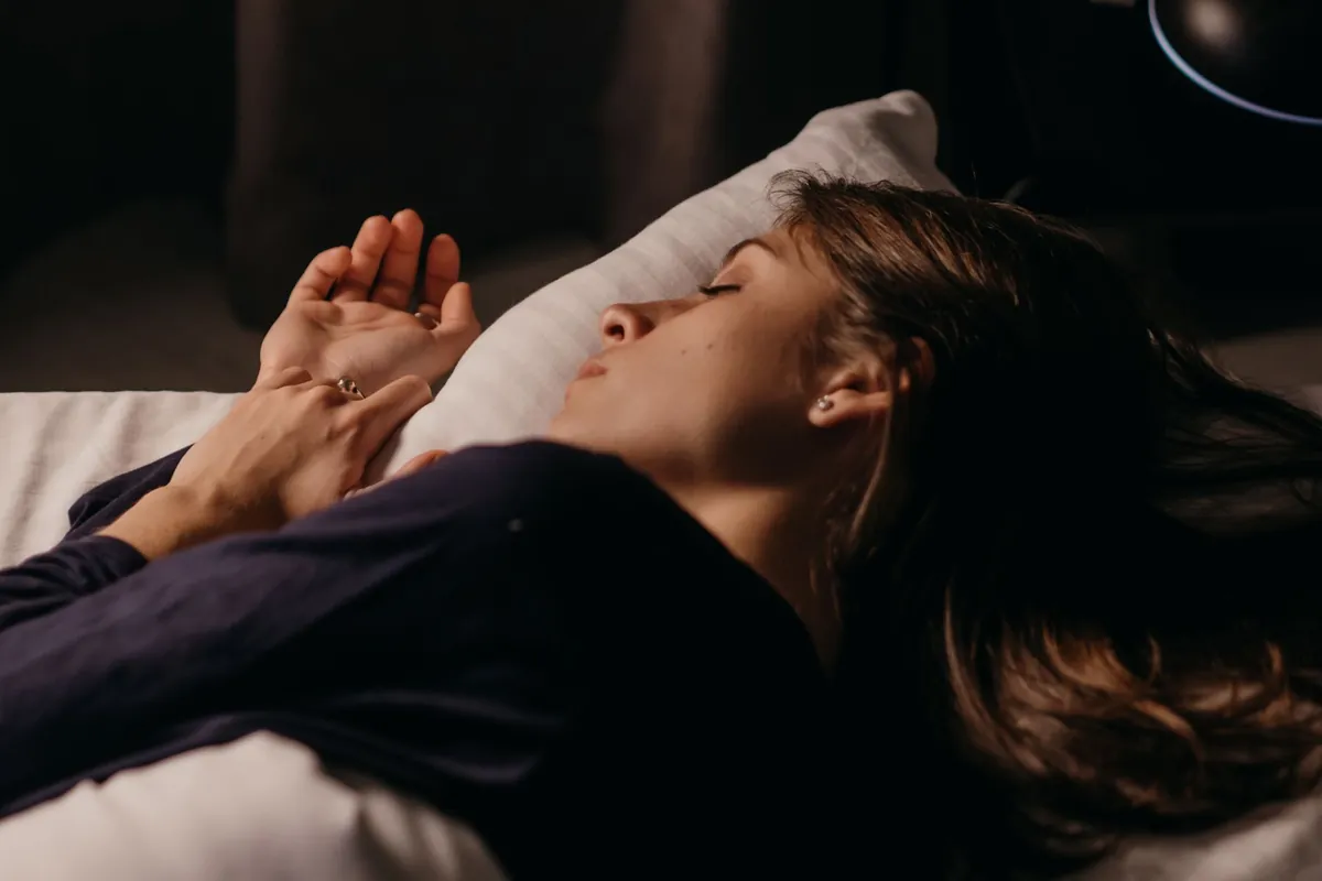 A person sleeping soundly in a comfortable bed, illustrating the benefits of unlocking their best sleep for energy and focus.