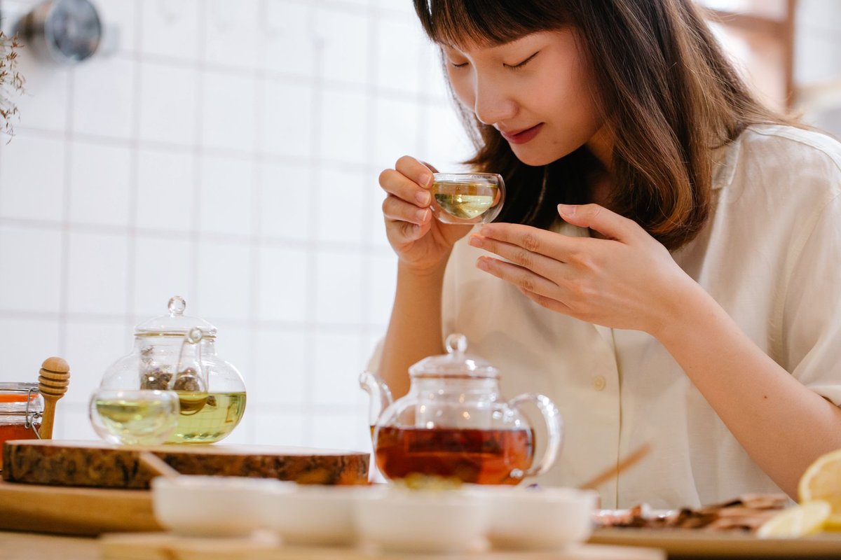 A happy person in a sunlit kitchen holding a warm mug, reflecting healthy longevity habits.