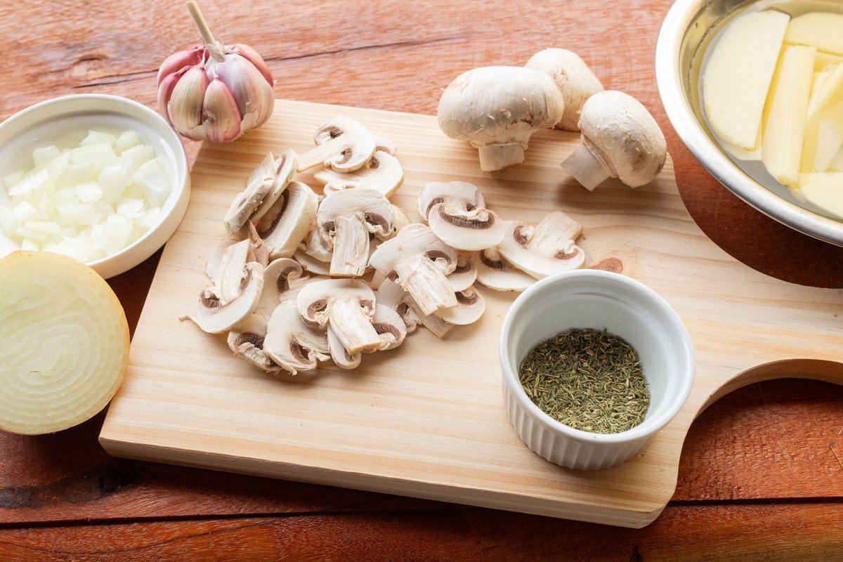 Fresh whole foods like greens and salmon placed on a rustic wooden kitchen counter