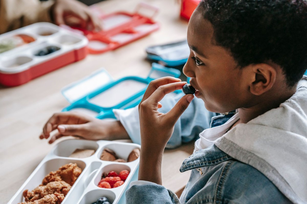 A young person holding a healthy colorful snack featuring fresh fruits and micronutrient dense ingredients