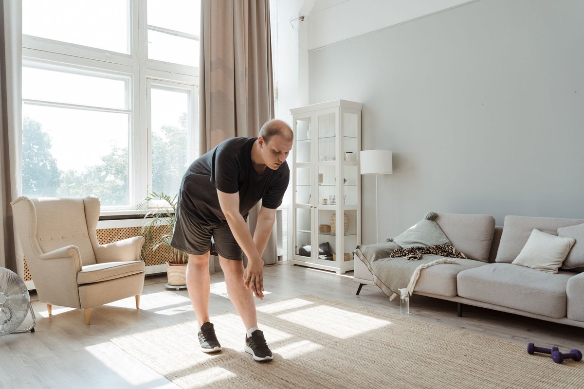 A person doing a bodyweight strength exercise in a cozy living room space.